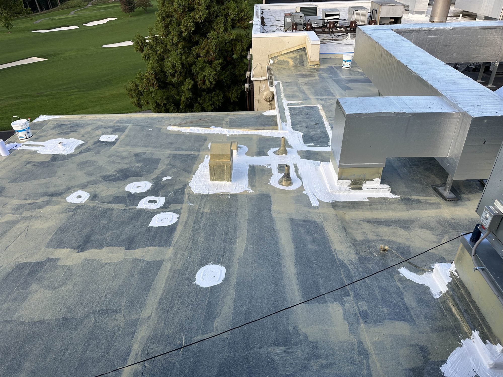 Priming and detailing a large commercial flat roof before coating